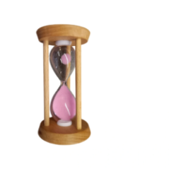 Close-up of the glass bulb of the hourglass with pink sand and wooden construction